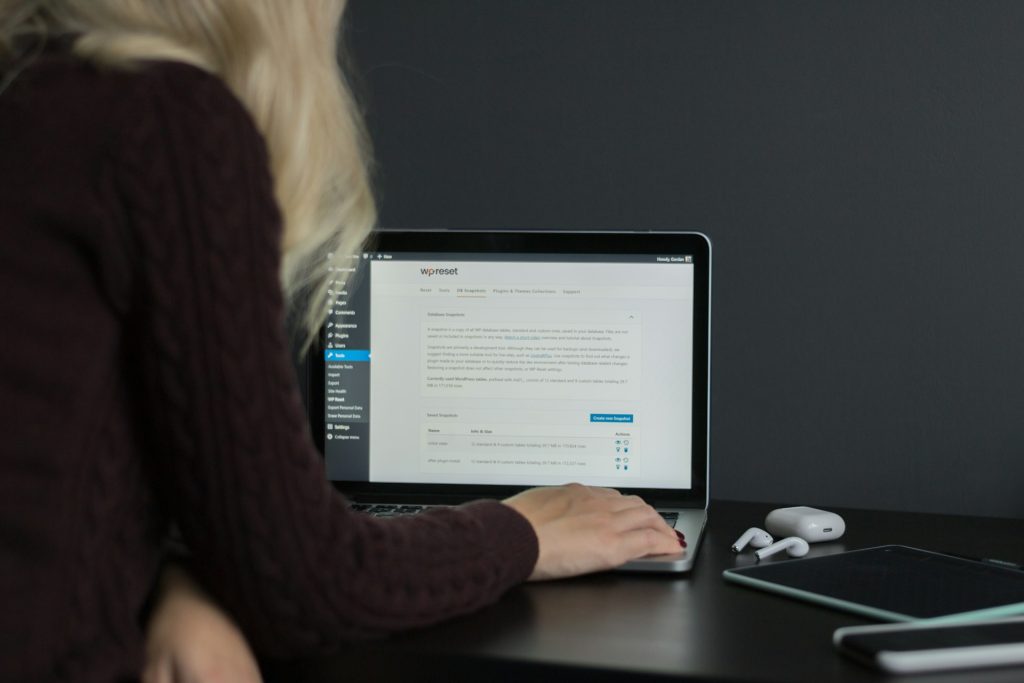 a woman in a black sweater using a MacBook Pro